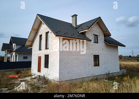 Vista aerea di casa incompiuta con pareti in calcestruzzo leggero aerato e telaio del tetto in legno rivestito con piastrelle metalliche in costruzione Foto Stock