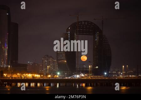 Baku. Azerbaigian. 01.29.2021 anno. La luna piena sorge sopra la città tra gli edifici. Foto Stock