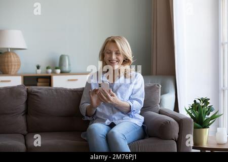 Felice pensionato donna matura sorridente al display del cellulare Foto Stock