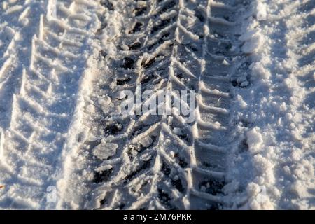 Cingoli pneumatici per auto. Strada innevata e ghiacciata, pericolosa e non sicura. Inverno mattina. Foto Stock