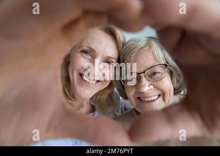 Madre anziana felice e donna figlia matura che guarda la macchina fotografica Foto Stock