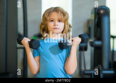 Esercizi sportivi per bambini. Vita sana dei bambini e concetto di sport. Ritratto del bambino che lavora fuori con i manubri. Motivazione e concetto di sport per Foto Stock