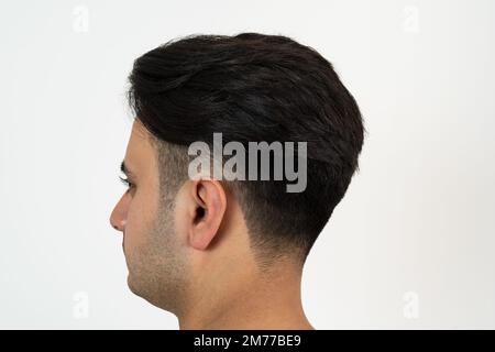 Ritratto di un uomo marrone con pelle e capelli neri ben curati e setosi su sfondo bianco isolato. Foto Stock