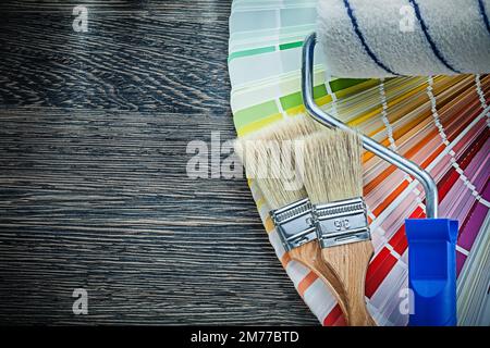 Spazzole a rullo colore pantone FAN su tavola di legno. Foto Stock