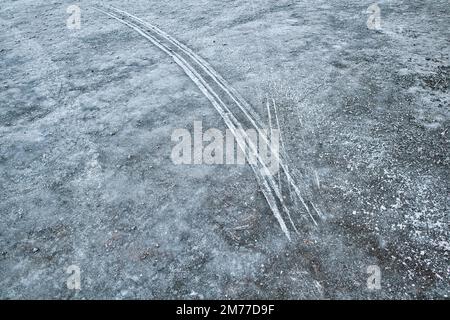 segni di chiodatura degli pneumatici su terreno ghiacciato Foto Stock