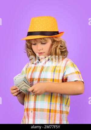 Denaro contante dollari fatture. Capretto che mostra le fatture del dollaro dei soldi, levante in piedi sognante dei ricchi contro lo sfondo isolato dello studio. Foto Stock