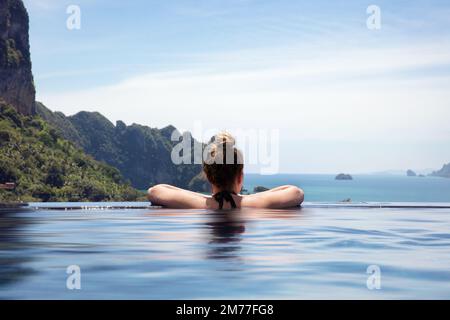 Donna di riposo in piscina a sfioro a Aonang Beach Resort Foto Stock