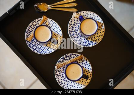 Caffè turco o francese con delizia in schiuma e set di servizio tradizionale. Set da caffè in ceramica blu e bianca Foto Stock