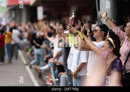 I cattolici filippini agitarono le mani in aria e sorreggono le statuine di Santo Nino mentre la canzone religiosa Batobalani sa Gugma viene suonata al B Foto Stock