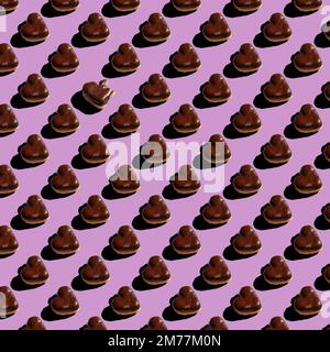 motivo senza cuciture di ciambelle a forma di cuore al cioccolato su sfondo viola Foto Stock