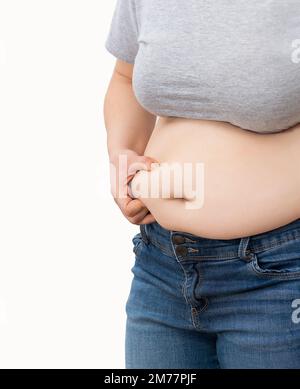 Primo piano di una giovane donna obesa che controlla i suoi grassi Foto Stock