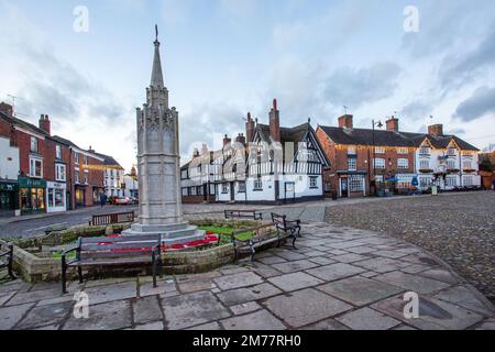 La piazza del mercato acciottolata nella città di Sandbach in Cheshire con il suo memoriale di guerra cenotafio e la locanda in bianco e nero Foto Stock