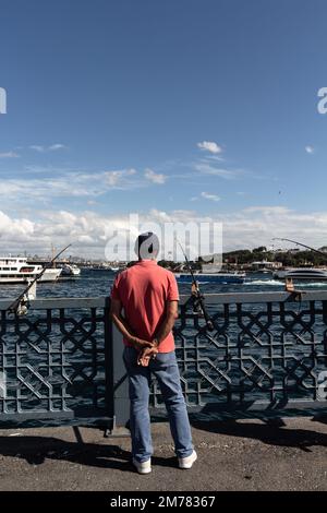 Vista dell'irriconoscibile pescatore sul ponte Galata di Istanbul. L'immagine riflette lo stile di vita e la cultura della gente locale è una giornata estiva di sole. Foto Stock