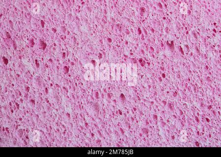 Sfondo poroso con texture rosa. Gomma spugna macro foto. Spazio di copia Foto Stock