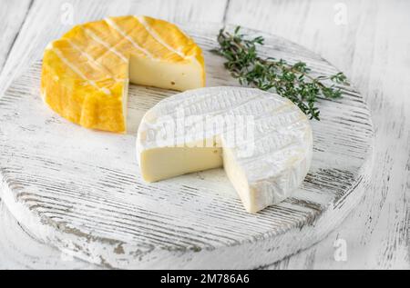 Due ruote per formaggio a camembert sul tagliere Foto Stock