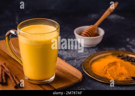 Latte di curcuma, latte d'oro, bevanda salutare con cannella e spezie. Foto Stock