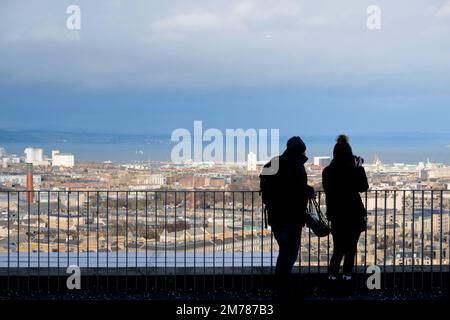 Edimburgo, Scozia, Regno Unito. 8th gennaio 2023. I visitatori della collina di Calton si sono avvolti contro il freddo vento e le mutevoli condizioni atmosferiche. Vista verso nord sui tetti della città verso il quarto estuario. Credit: Craig Brown/Alamy Live News Foto Stock