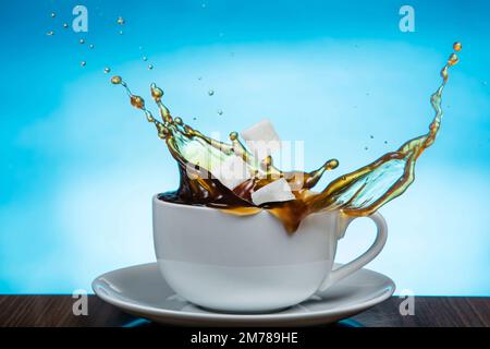 I cubetti di zucchero cadono in una tazza di caffè. Foto Stock