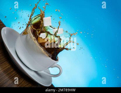 I cubetti di zucchero cadono in una tazza di caffè. Foto Stock