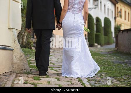 la sposa e lo sposo camminando lungo la strada storica della città Foto Stock