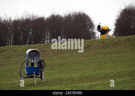 Gersfeld, Germania. 08th Jan, 2023. Cannoni da neve inutilizzati si trovano accanto allo skilift Zuckerfeld, sul prato verde. La mancanza di neve e le temperature miti impediscono alle stazioni sciistiche di Hesse di godersi le piste. Credit: Sebastian Gollnow/dpa/Alamy Live News Foto Stock