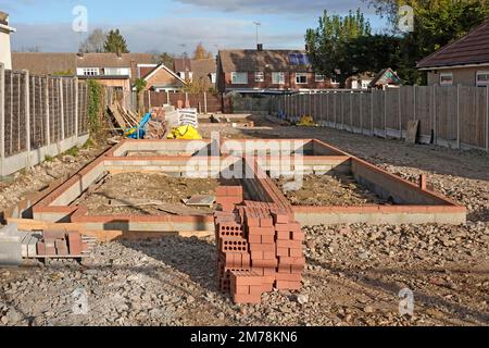 Nuova casa indipendente costruzione sottostruttura progresso mattoni rossi e blocchi di calcestruzzo formano pareti portanti su fondamenta di trincea in calcestruzzo Inghilterra UK Foto Stock