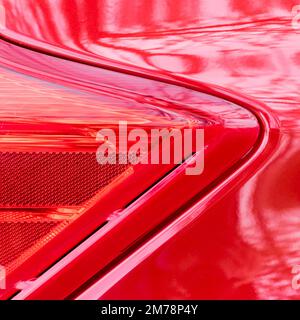 Dettagli della forma geometrica della luce di segnalazione di un'auto rossa e dei suoi riflessi Foto Stock
