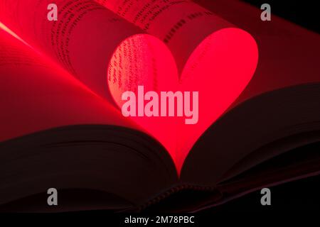 Forma a cuore rosso formata da pagine di un romanzo romantico Foto Stock