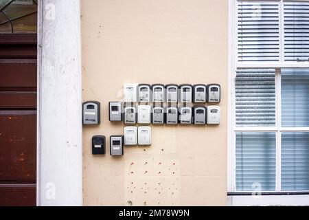 Piccole casseforti con chiavi che contengono le chiavi di un edificio fissato con serrature a combinazione attaccate a una parete Foto Stock