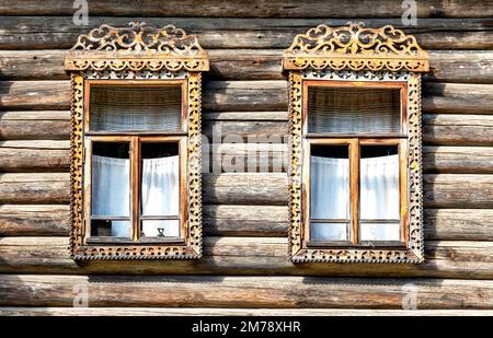 Finestre di vecchia casa di tronchi tradizionale russa con rivestimento in legno intagliato Foto Stock