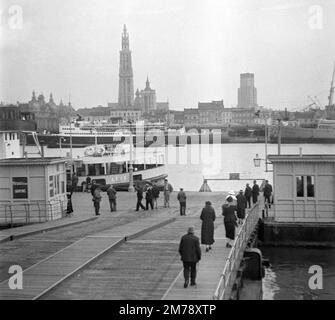 Traghetto sul fiume Scheldt e vista panoramica, skyline o paesaggio urbano della città vecchia di Anversa con la Cattedrale di nostra Signora. Belgio. Immagine vintage in bianco e nero o monocromatica c1940. Foto Stock