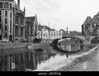 1960s Vista del Riverside Graslei Quay sul fiume Leie, e il Ponte medievale di San Michele, nella città vecchia o nel quartiere storico di Gand Belgio c1960. Fotografia vintage in bianco e nero o monocromatica. Foto Stock