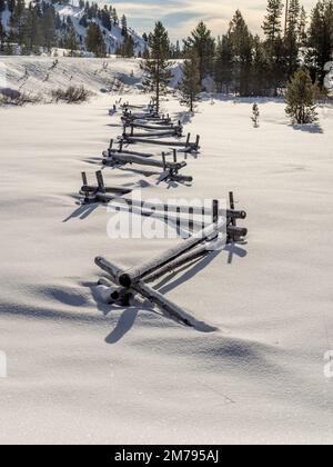 Neve invernale vicino a Stanley Idaho con l'iconica recinzione di tronchi Foto Stock