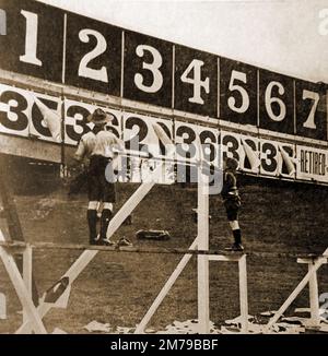 1930's, circuito automobilistico di Brooklands UK . Un ragazzo scout e cucciolo segnano i giri completati da ogni concorrente sulla bacheca pubblica. Foto Stock