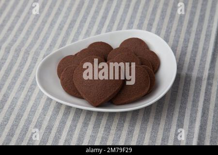 biscotti al cioccolato a forma di cuore isolati sulla tovaglia Foto Stock