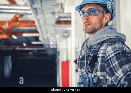 Tecnico addetto alla manutenzione dell'impianto di riscaldamento, condizionamento e ventilazione che entra nell'edificio commerciale per avviare il controllo dei condotti dell'aria. Foto Stock