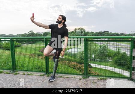 Uomo ispanico con gamba protesica che prende selfie dopo la routine di allenamento Foto Stock