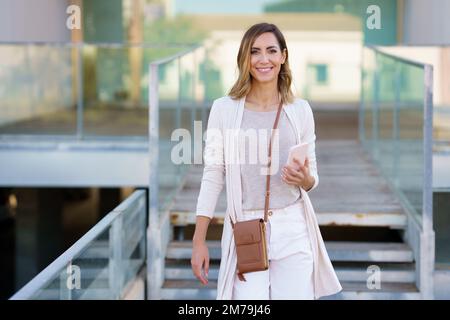 Felice femmina con smartphone vicino a pochi passi Foto Stock