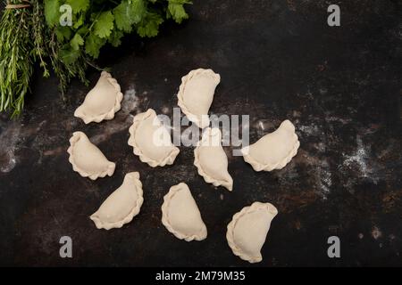 Gnocchi fatti a mano in casa su uno sfondo rustico insieme alle erbe Foto Stock