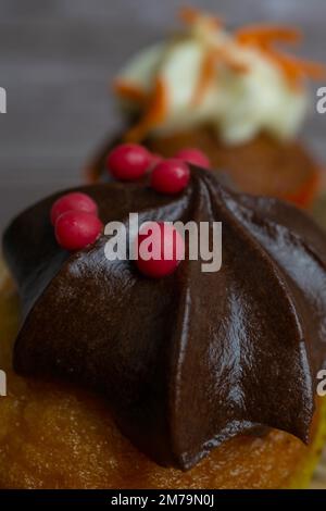 Assortimento di cupcake al cioccolato e alla crema e alla carota su vari sfondi Foto Stock