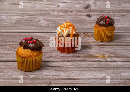 Assortimento di cupcake al cioccolato e alla crema e alla carota su vari sfondi Foto Stock
