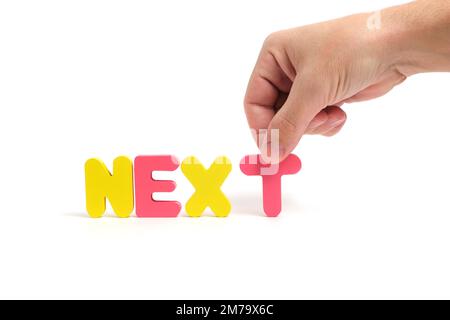 Man Hand compone la parola seguente in lettere su sfondo bianco Foto Stock
