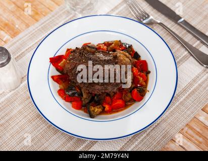 Maiale al forno con contorno di verdure saltate sul piatto Foto Stock