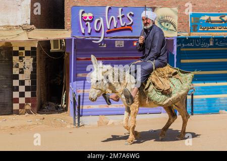 DAKHLA, EGITTO - 8 FEBBRAIO 2019: L'anziano locale che cavalca un asino nel villaggio di al Qasr nell'oasi di Dakhla, Egitto Foto Stock