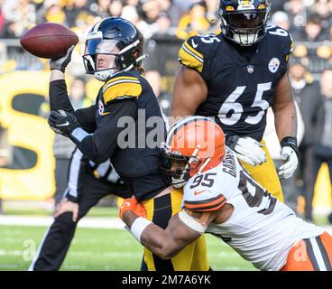 Pittsburgh, Stati Uniti. 08th Jan, 2023. Kenny Pickett (8) completa il passaggio mentre si trova nelle mani del Cleveland Browns Defensive End Myles Garrett (95) durante il secondo trimestre all'Acrisure Stadium di domenica 8 gennaio 2023 a Pittsburgh. Foto di Archie Carpenter/UPI Credit: UPI/Alamy Live News Foto Stock