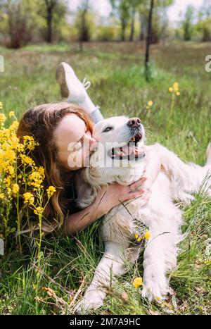 Giovane bella donna e il suo cane Golden Retriever divertirsi in estate Foto Stock