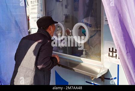 La gente prende i loro ultimi campioni liberi di test di acido nucleico ad un chiosco a Shanghai, Cina, 7 gennaio 2023. A partire da gennaio 8, in aggiunta al personale o Foto Stock