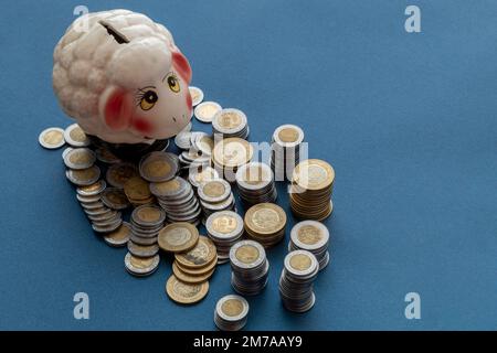 Pecora piggy bank con monete messicane pesos, gettate da un lato, e spazio per la copia. Foto Stock