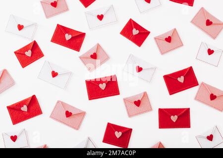 Molte buste di feltro con cuori su sfondo bianco Foto Stock