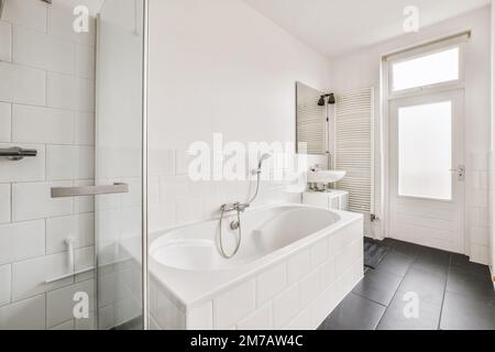 un bagno con piastrelle bianche e nere alle pareti, pavimento e vasca in un angolo Foto Stock